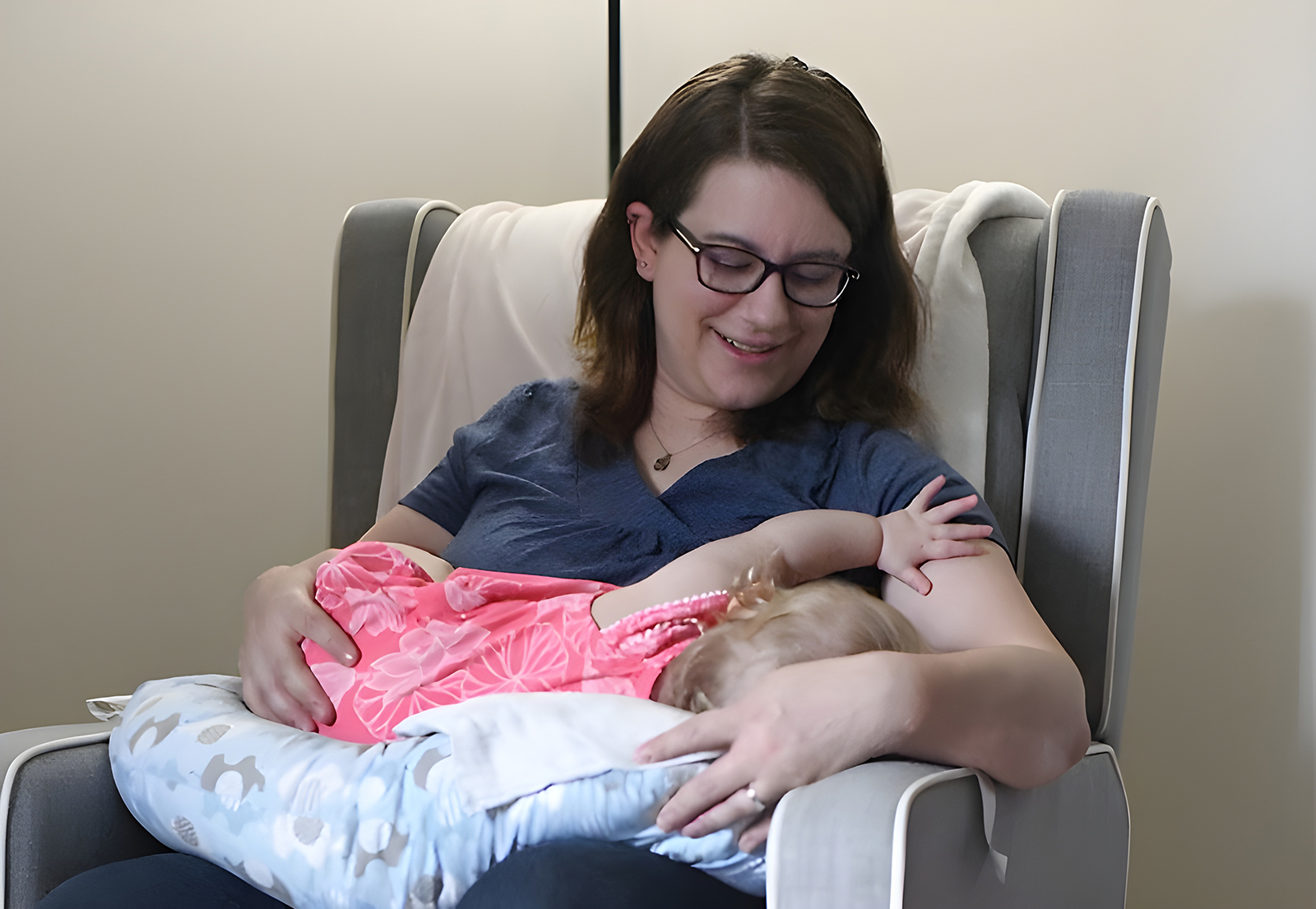 woman breastfeeding baby in pink dress