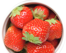 Fresh strawberries filling a white bowl.
